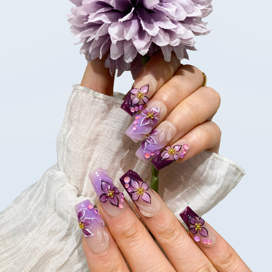 On-hand try-on of Midnight Blooms nails showing 3D purple petals and crystal beads