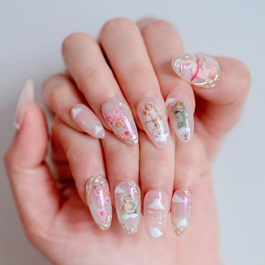 Cute cherry red and angel charm press-on nails on hand | Coquette aesthetic nail inspo