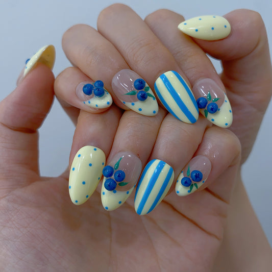 On-hand try-on of Blueberry Picnic nails showing 3D berries and blue polka dots