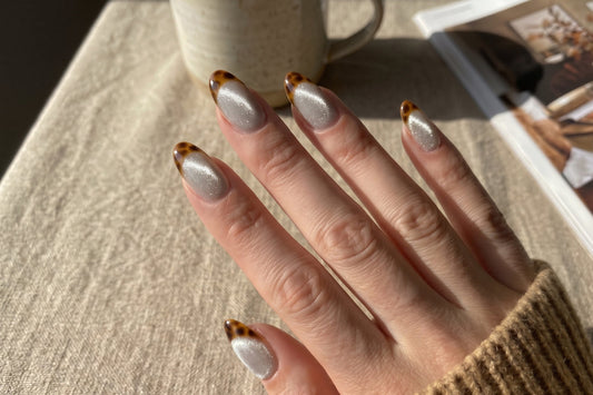 amber tortoiseshell fall press-on nails with cat-eye magnetic shimmer in natural daylight.