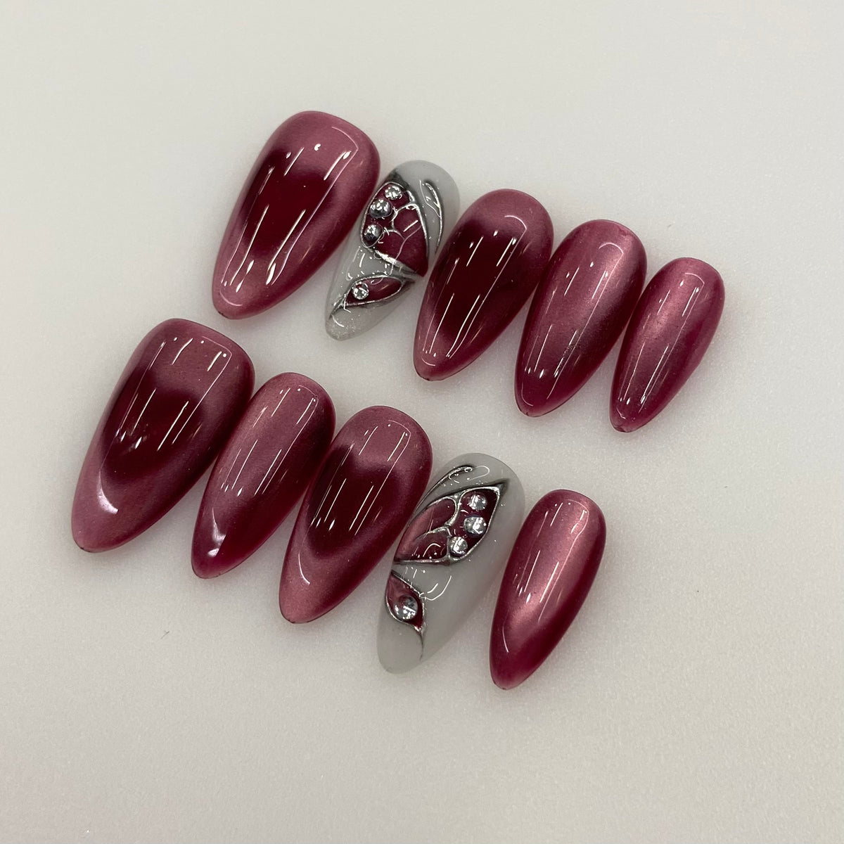 Full 10-piece set display of Burgundy Veil wine cat-eye press-on nails in light