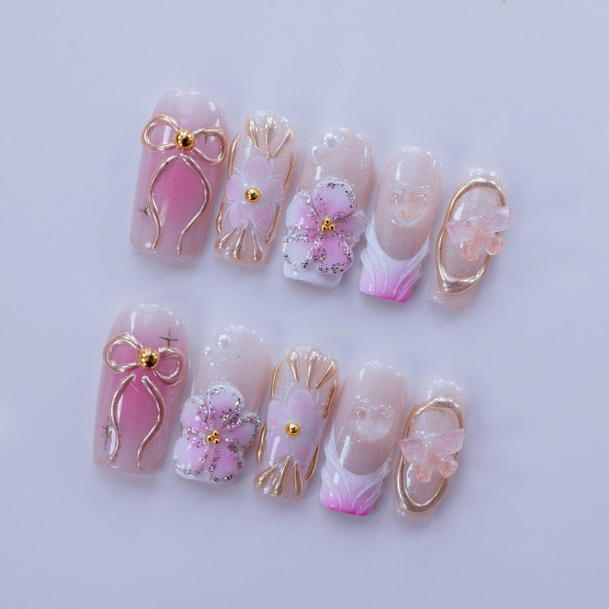 Angled view of Ribbon Dream nails showing 3D tulle butterfly and gold frames