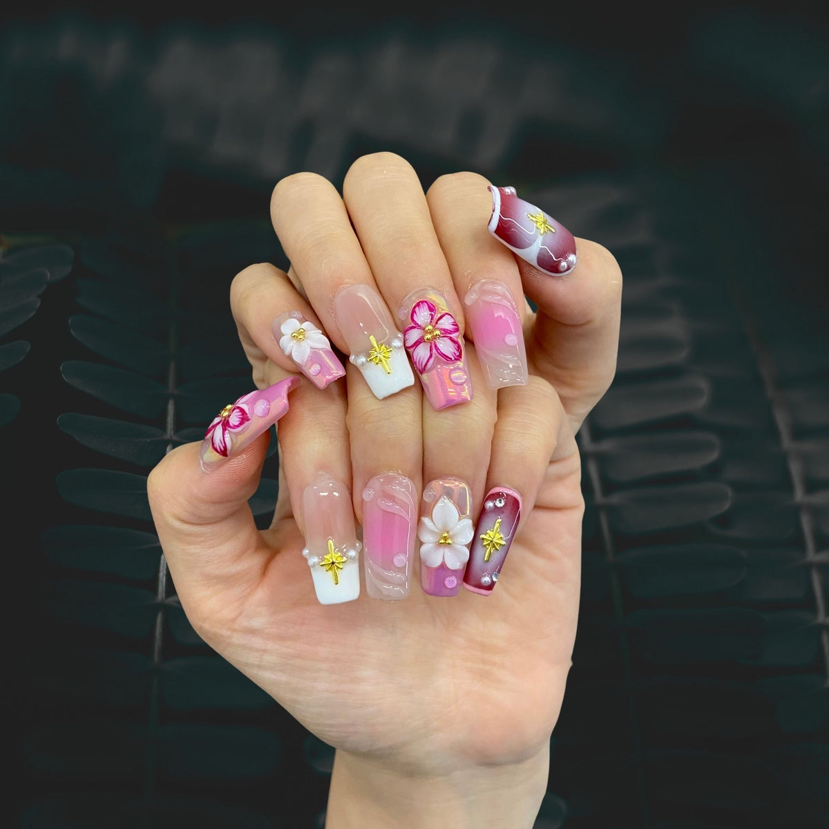 Blossom Fairy square press-on nails worn on hand in indoor lighting display