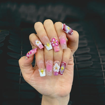 Blossom Fairy square press-on nails worn on hand in indoor lighting display