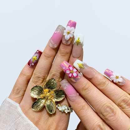 Full hand view of Blossom Fairy square nails paired with gold flower ring