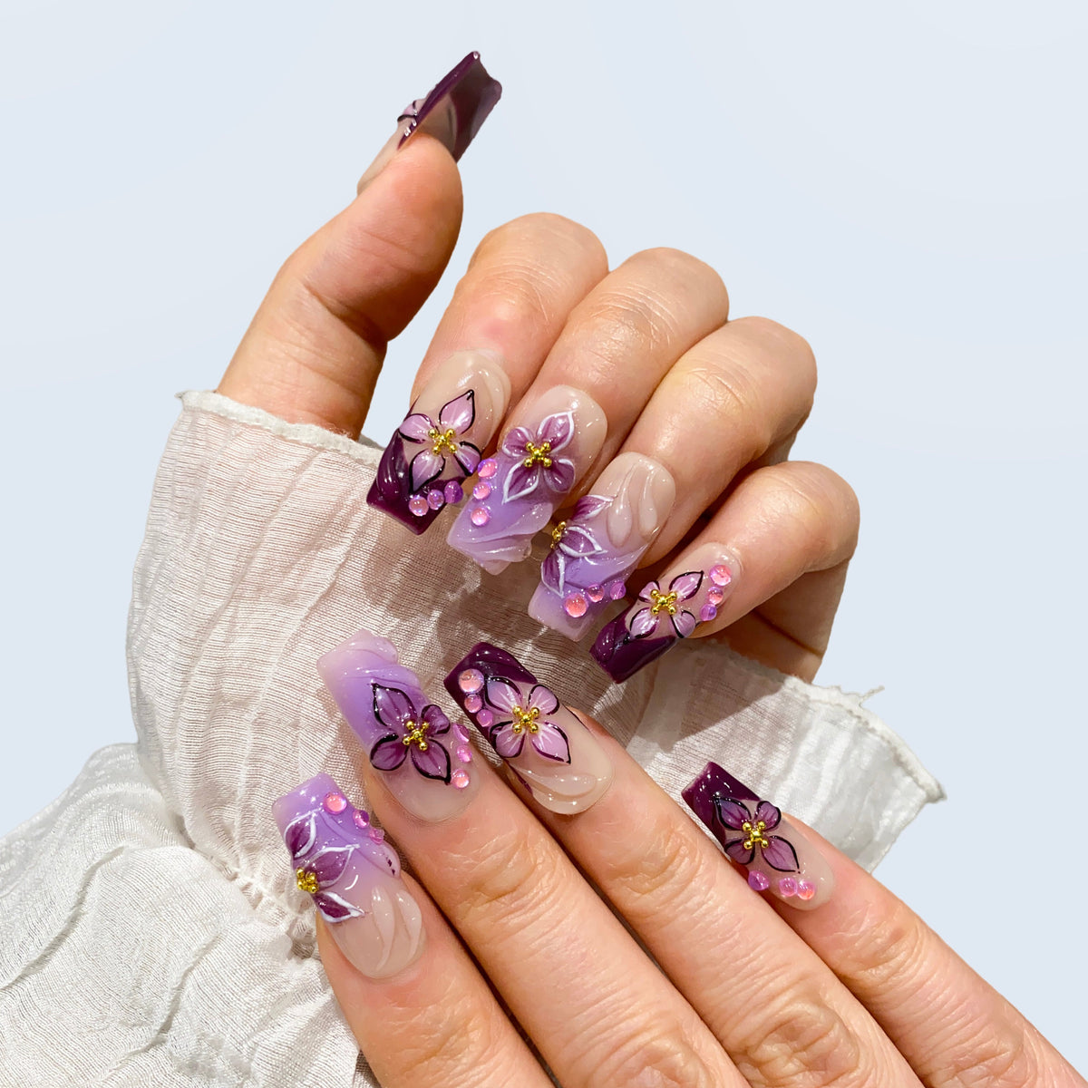 Angled view of Midnight Blooms square nails displaying 3D sculpted orchid petals