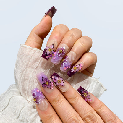Angled view of Midnight Blooms square nails displaying 3D sculpted orchid petals
