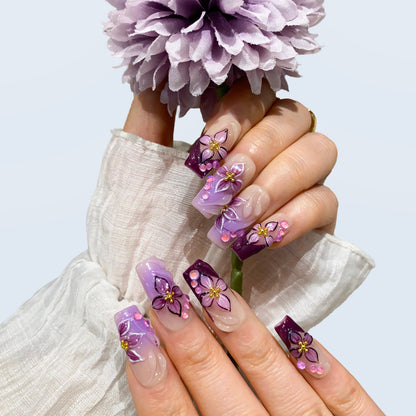On-hand try-on of Midnight Blooms nails showing 3D purple petals and crystal beads