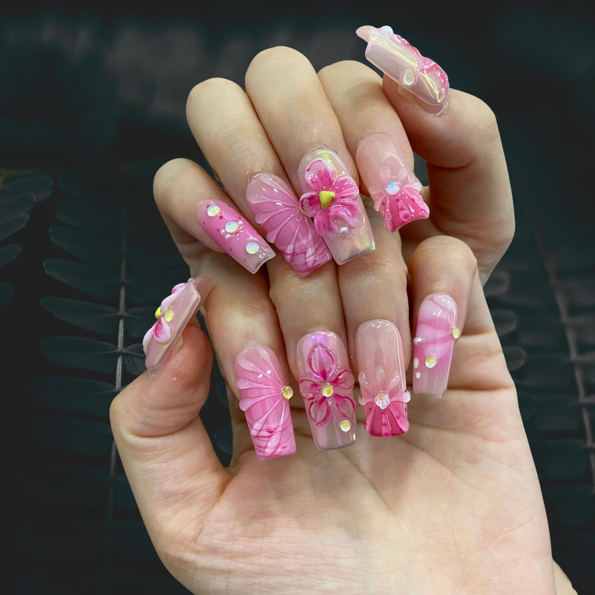Blush Bloom Spark medium square nails worn on hand in indoor ambient lighting