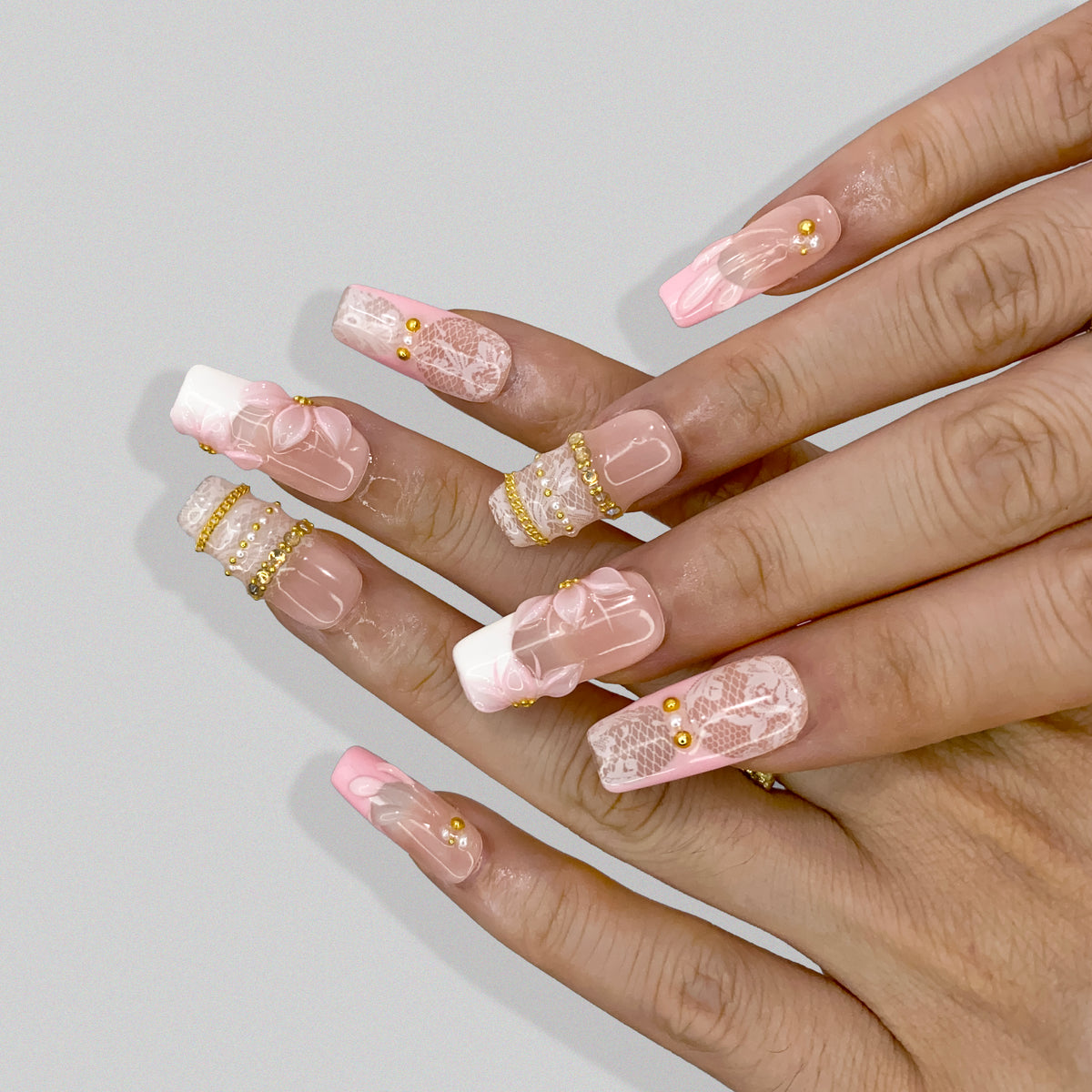 On-hand try-on of Blush Lace square press-on nails showing white lace and 3D floral art