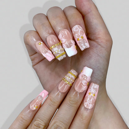 Lifestyle wear photo of Blush Lace nails highlighting gold beaded bangles and pearls