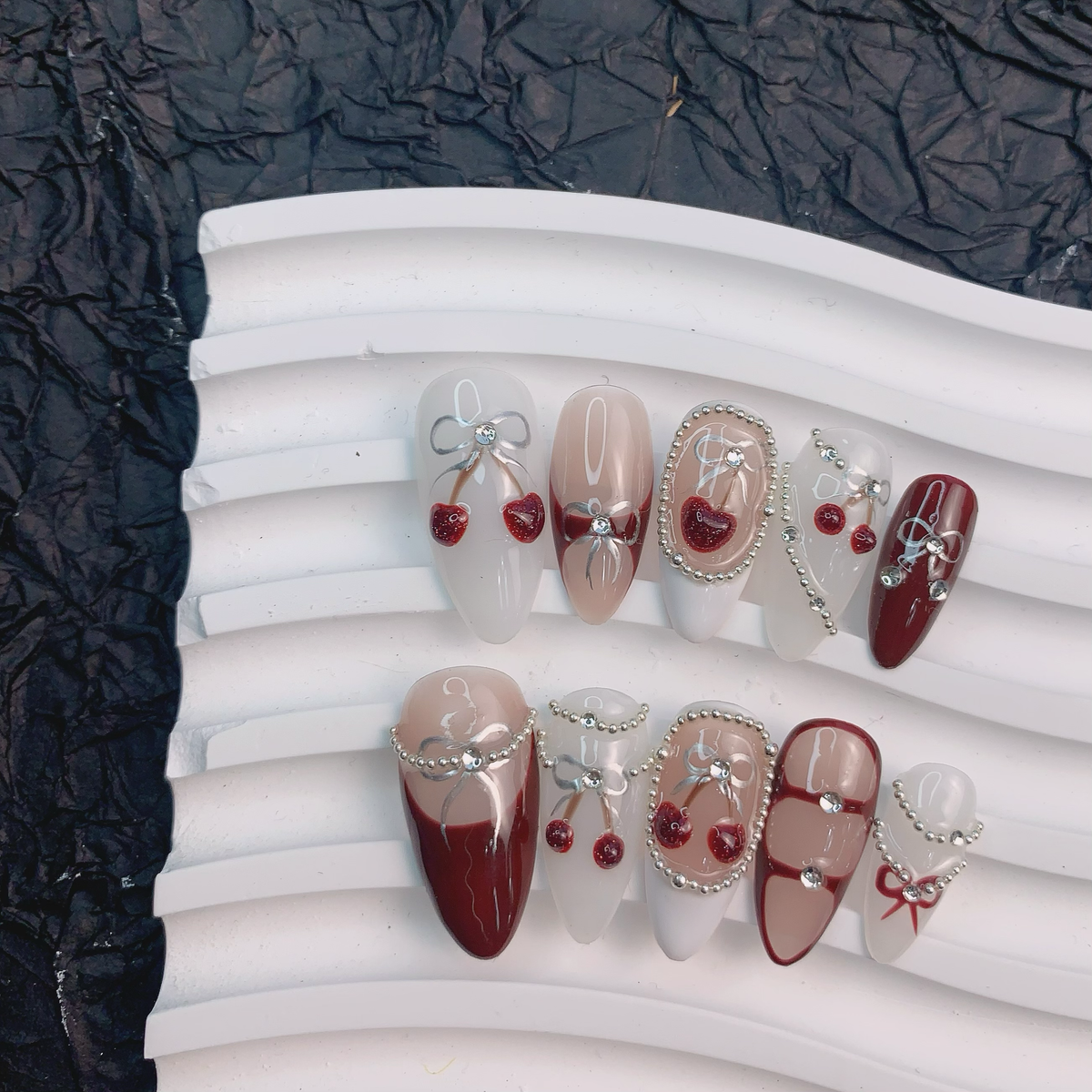 Coquette red press-on nails flat lay | Coquette nail inspo