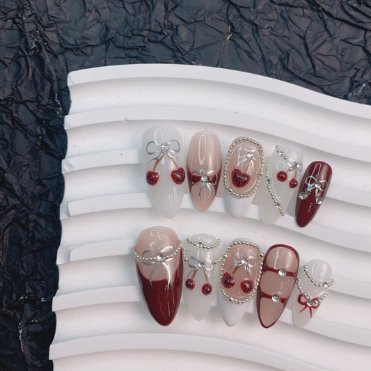 Coquette red press-on nails flat lay | Coquette nail inspo