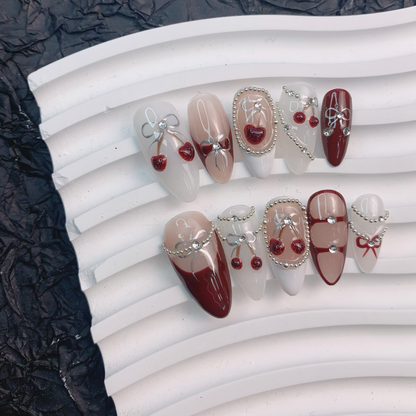 Cherry Bow nail art on flat surface close-up showing 3D ribbon bows on almond nails