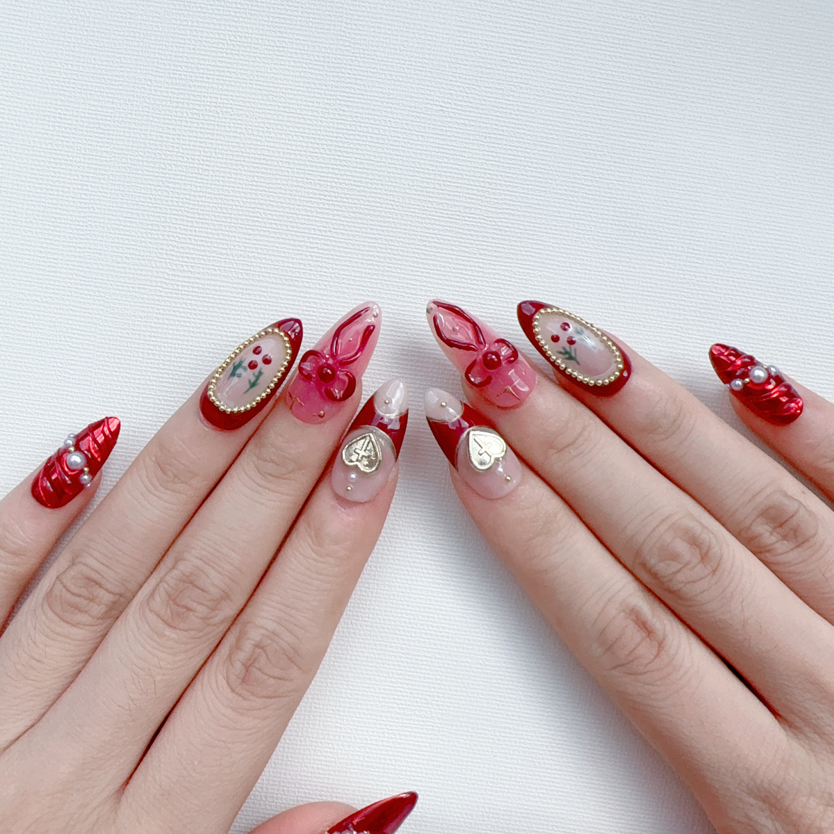 Angled view of Deck the Nails almond press-on nails displaying holly berry art