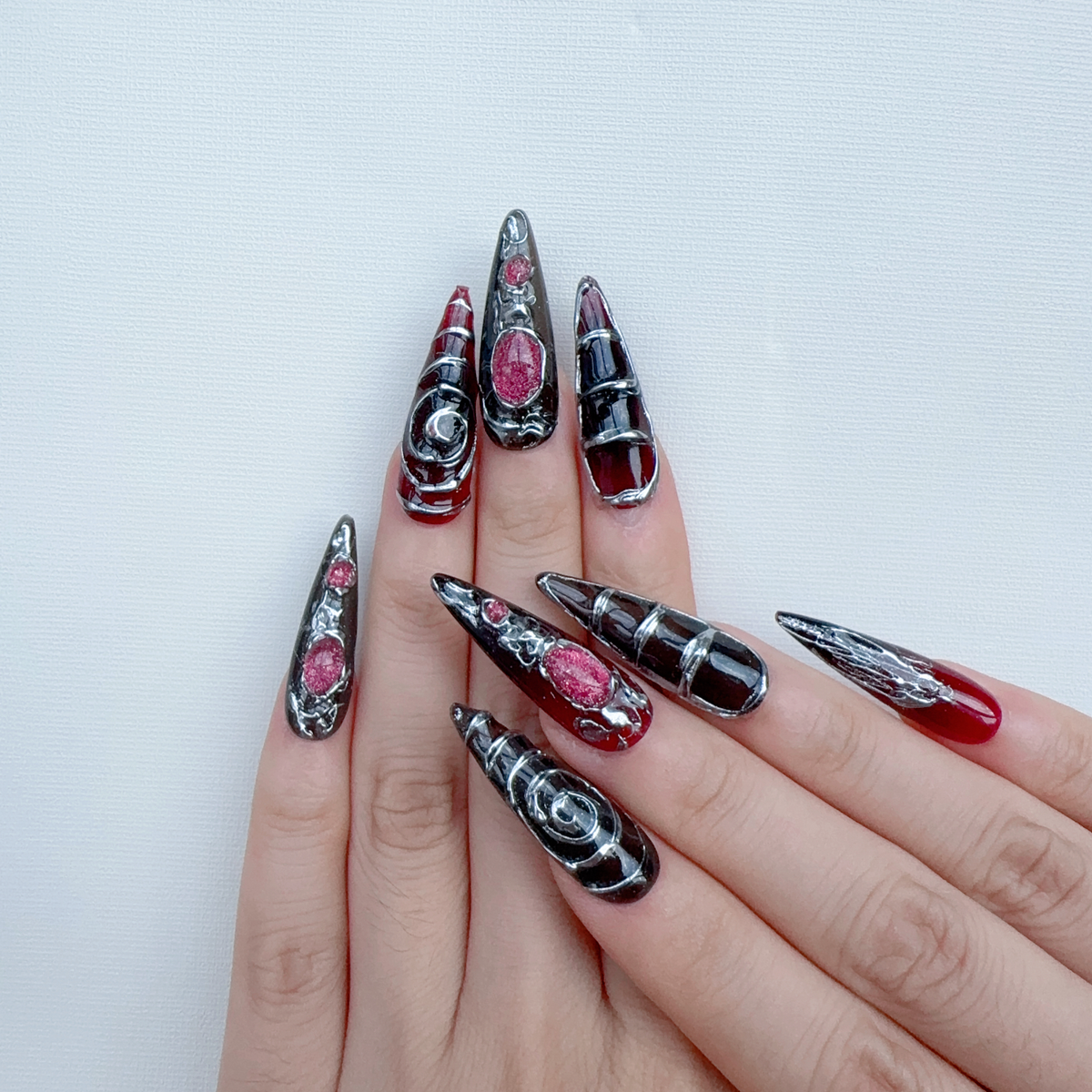 Both hands wearing Nocturnal Labyrinth molten silver stiletto press-on nails