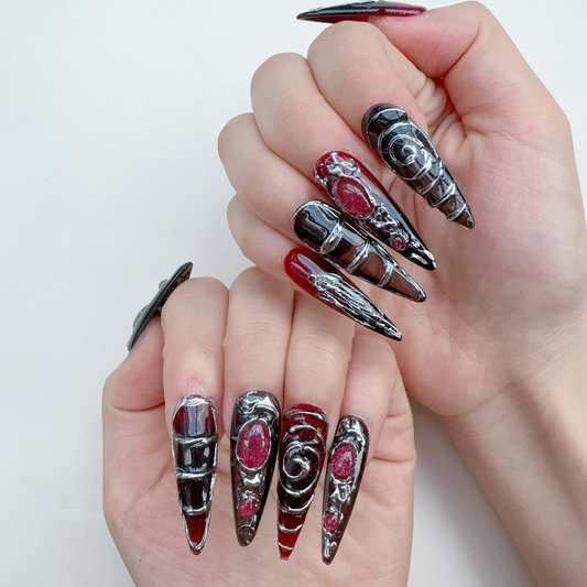 Gothic blood red ombre and metallic vein stiletto nails on hand | Dark fantasy nail inspo