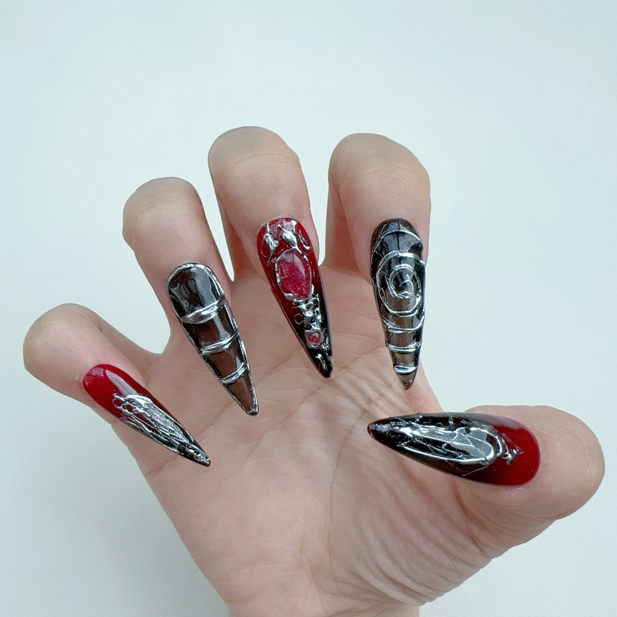 Single hand wearing Nocturnal Labyrinth gothic red aura stiletto press-on nails