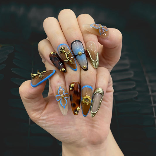 Vintage coastal blue and gold French stiletto nails on hand | Retro aesthetic nail inspo