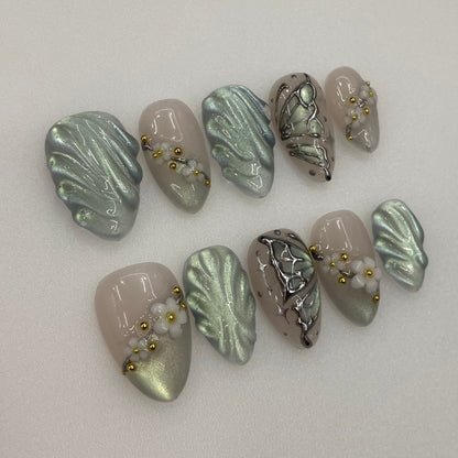 Sage Whisper nails showing raised 3D sculpted leaf textures and glossy gel shine