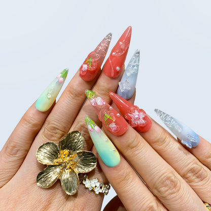 Blush Bloom stiletto nails styled with a gold statement flower ring on hand