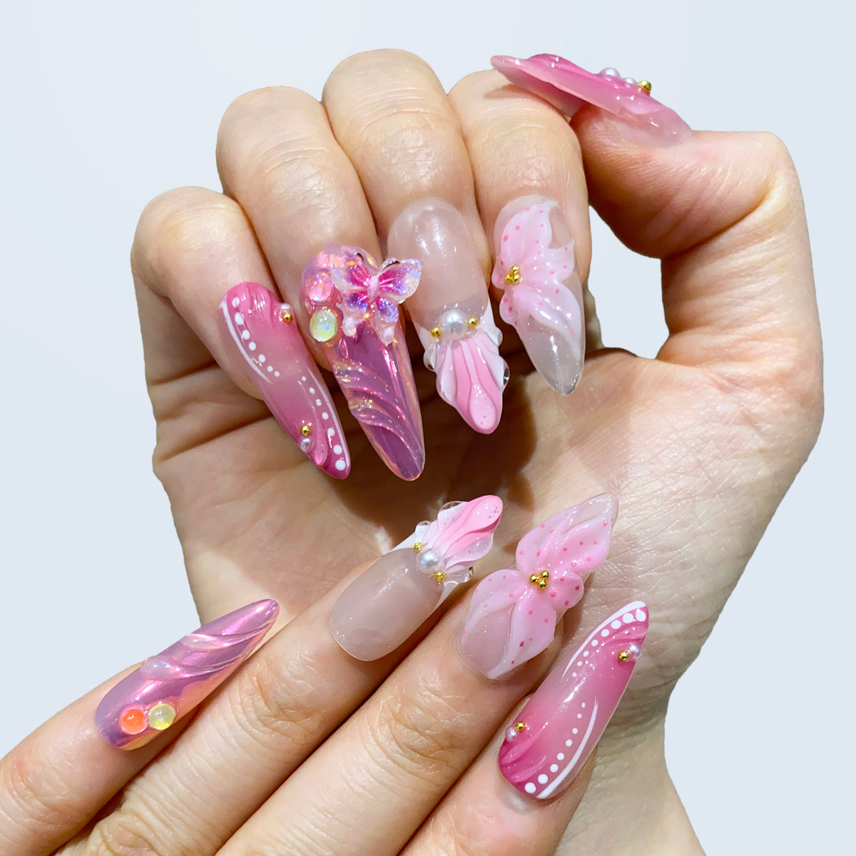 Full hand view of Butterfly Kisses almond nails showing glossy 3D shell petals