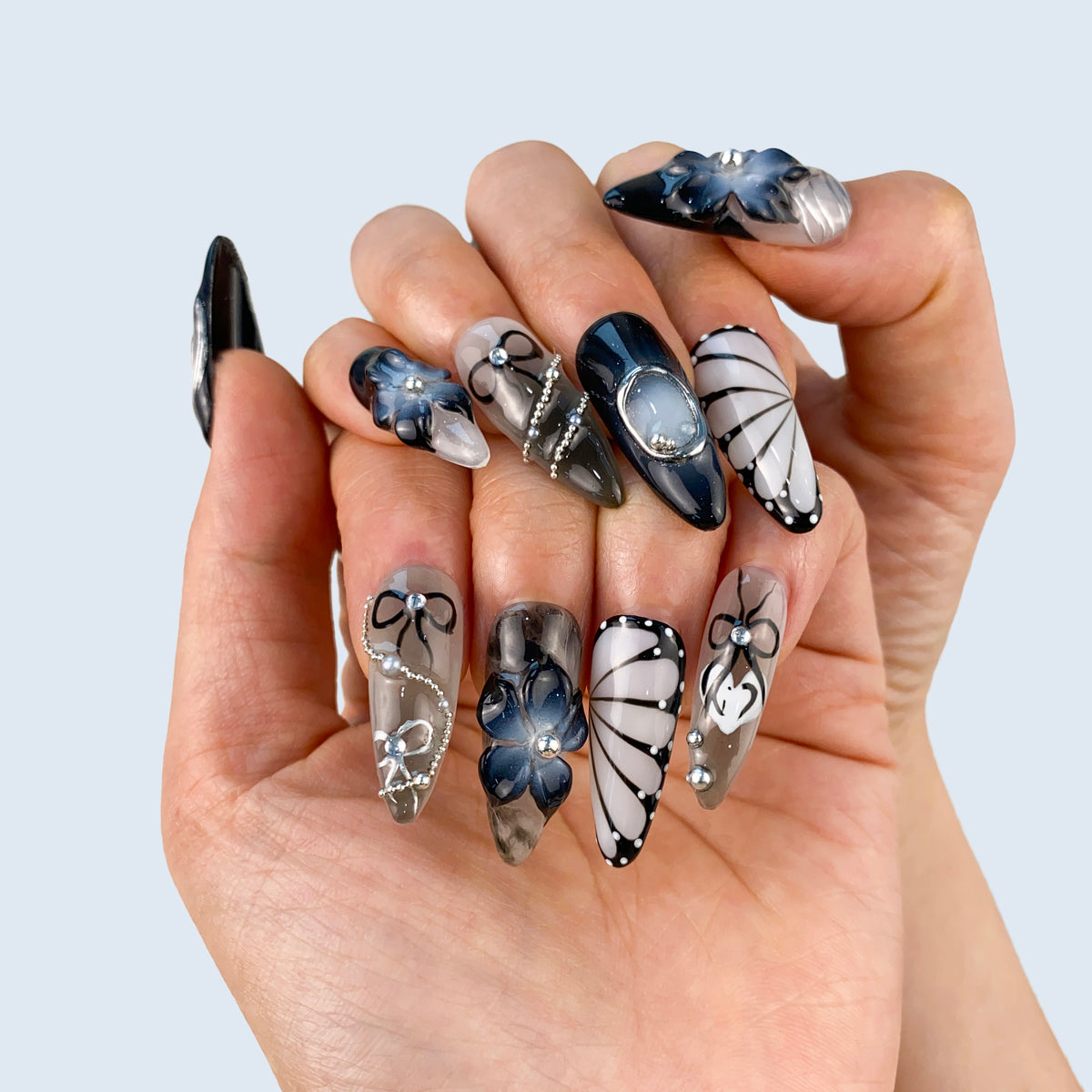 Full hand display of Noir Elegance stiletto nails with moody dark floral design