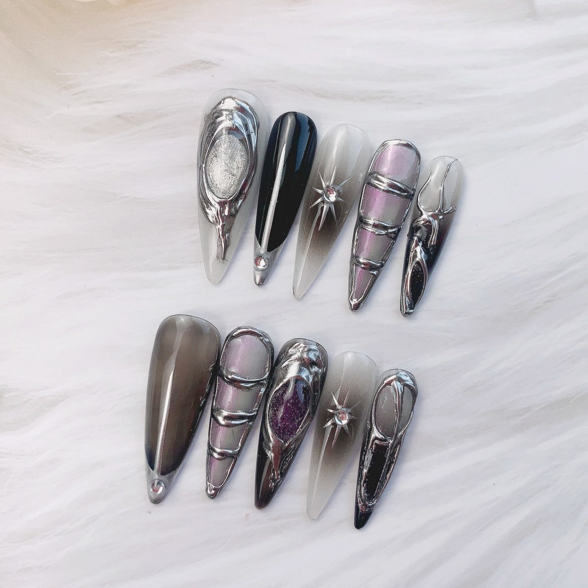 Phantom Aurora nail art on flat surface close-up showing celestial charms and aurora shimmer on stiletto nails