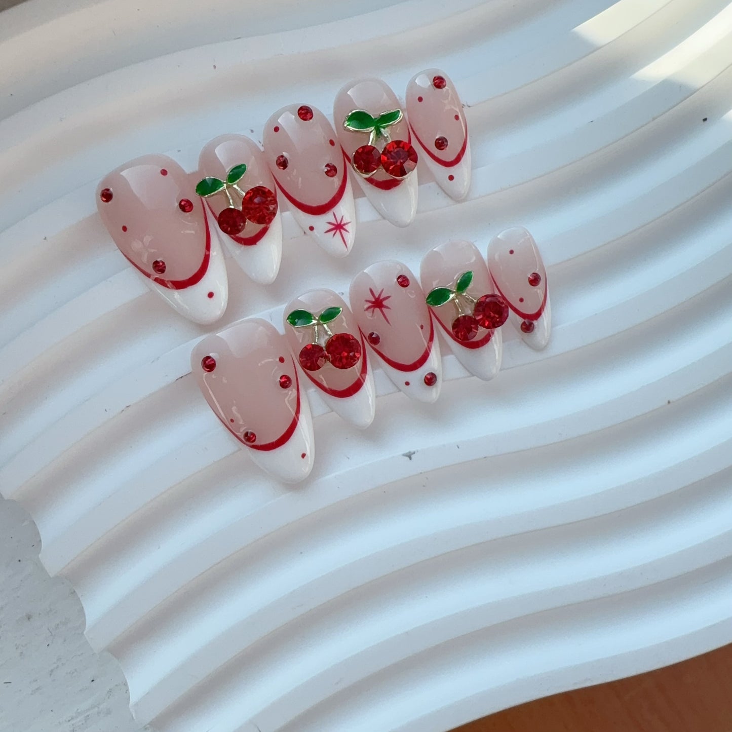 Ceramic tray flat lay of Velvet Cherry nails displaying glossy red cherries