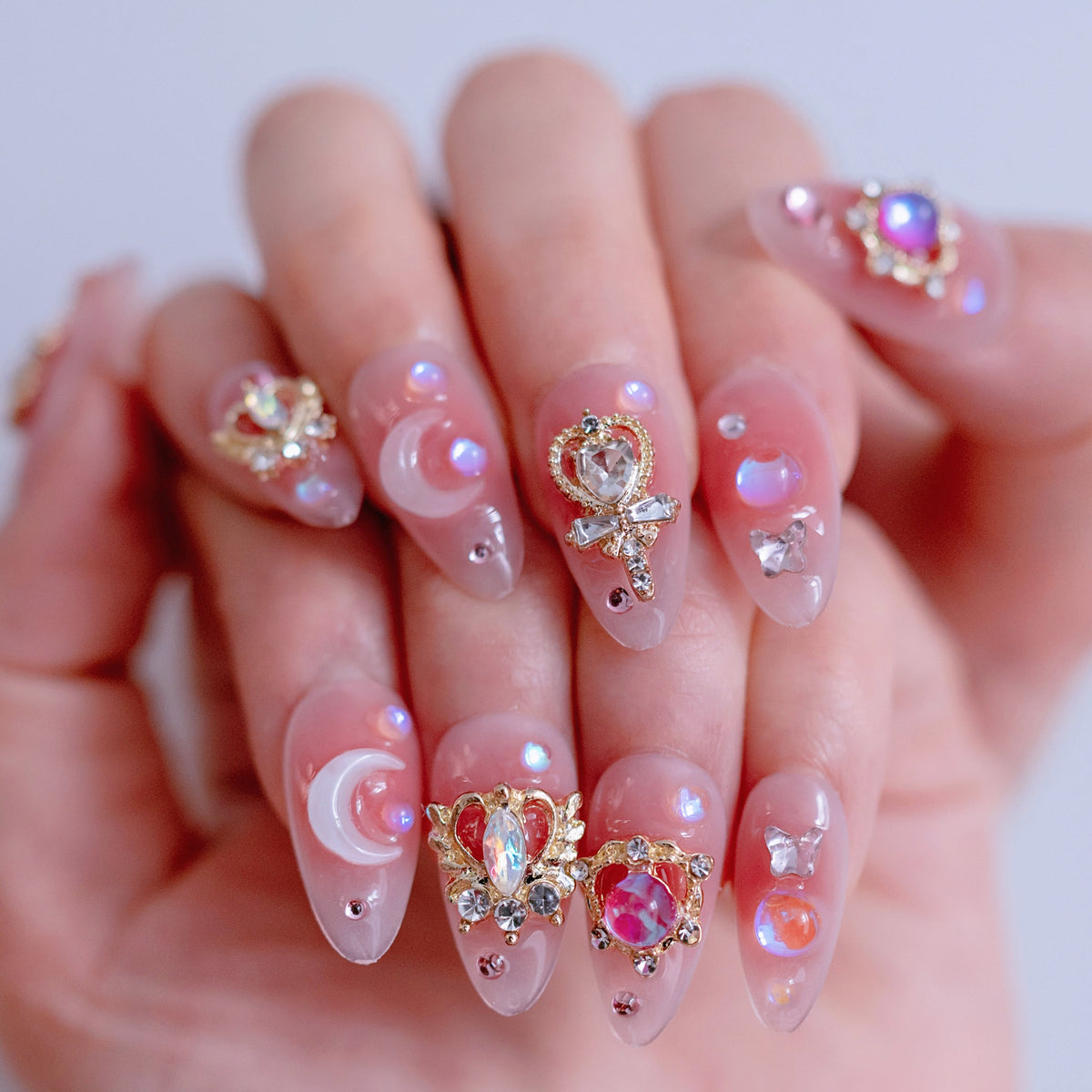 On-hand try-on of Moonlight Princess nails showing 3D pink crowns and scepters