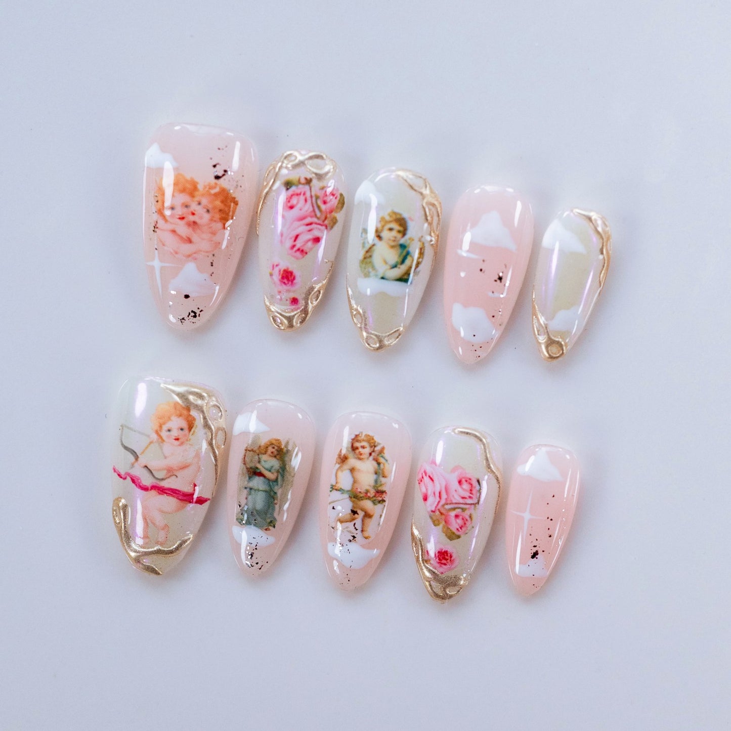 Angel's Love Story nail art flat lay close-up showing handcrafted art detailing on almond nails