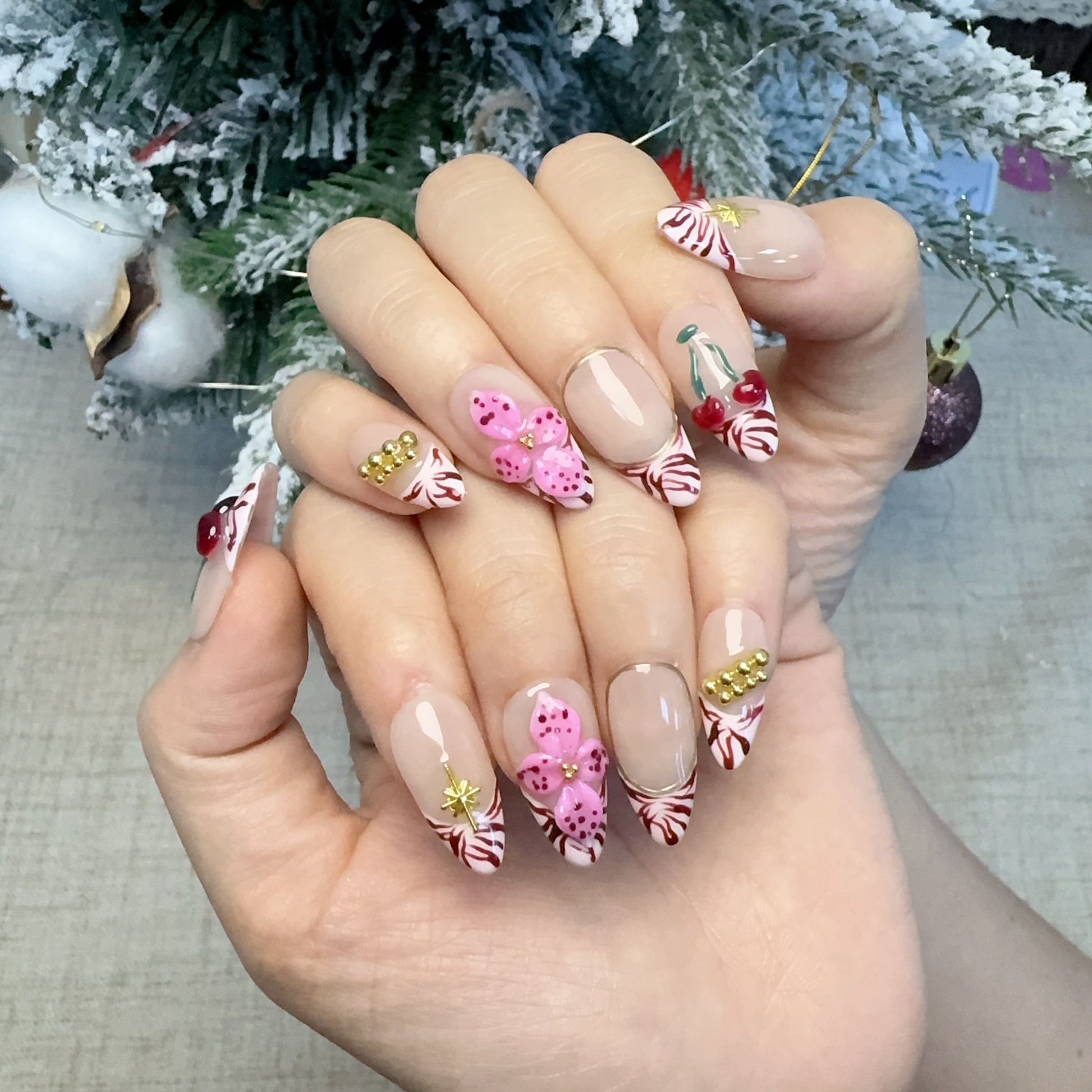Both hands wearing Royal Petals festive zebra French nails in holiday lighting