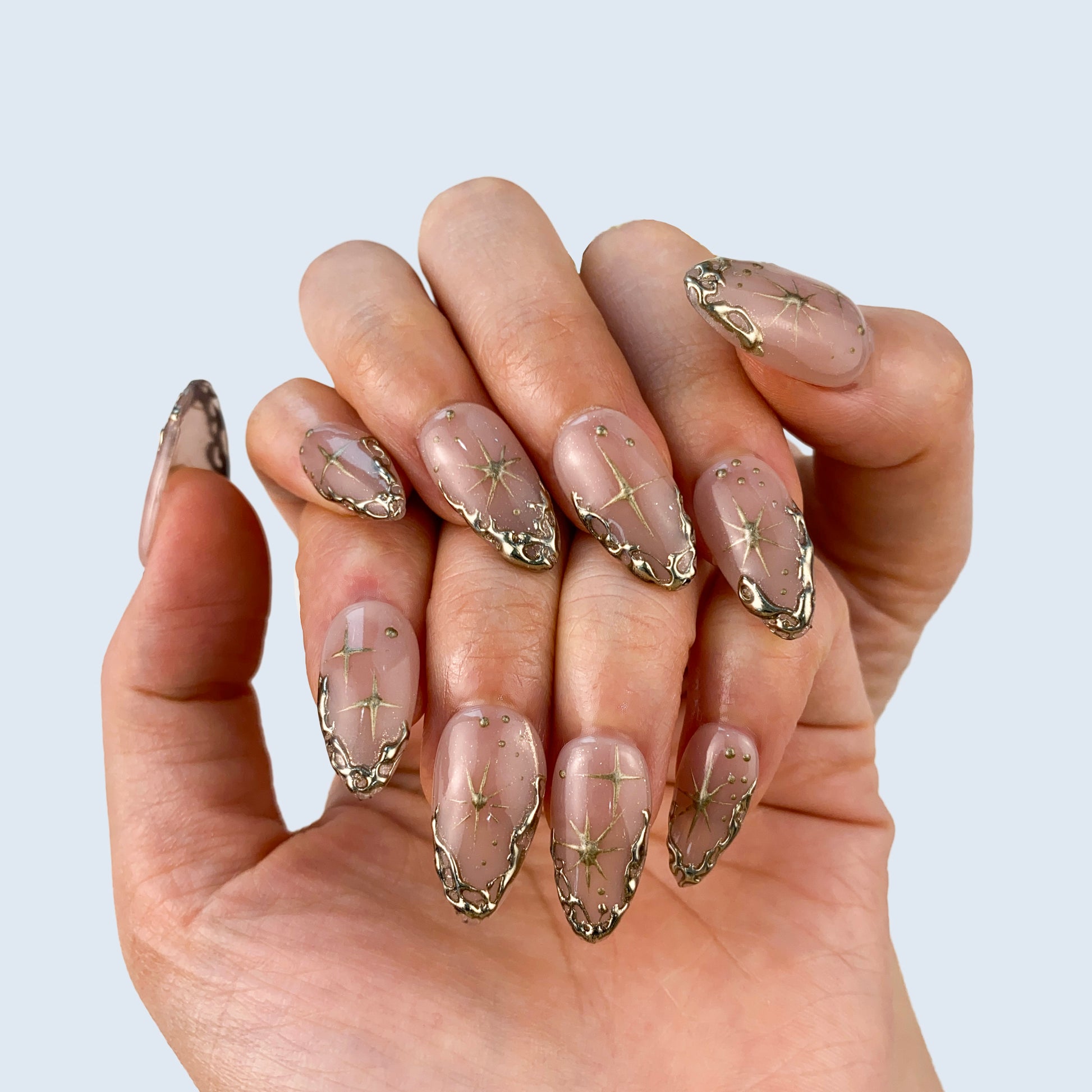 Gilded Serenity nail art close-up showing handcrafted art detailing on almond nails