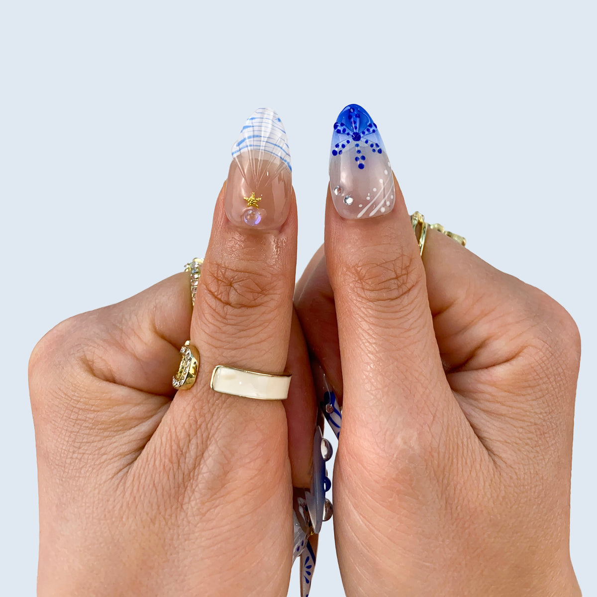 Thumbs closeup of Oceanic Mirage nails showing blue plaid French tips and flowers