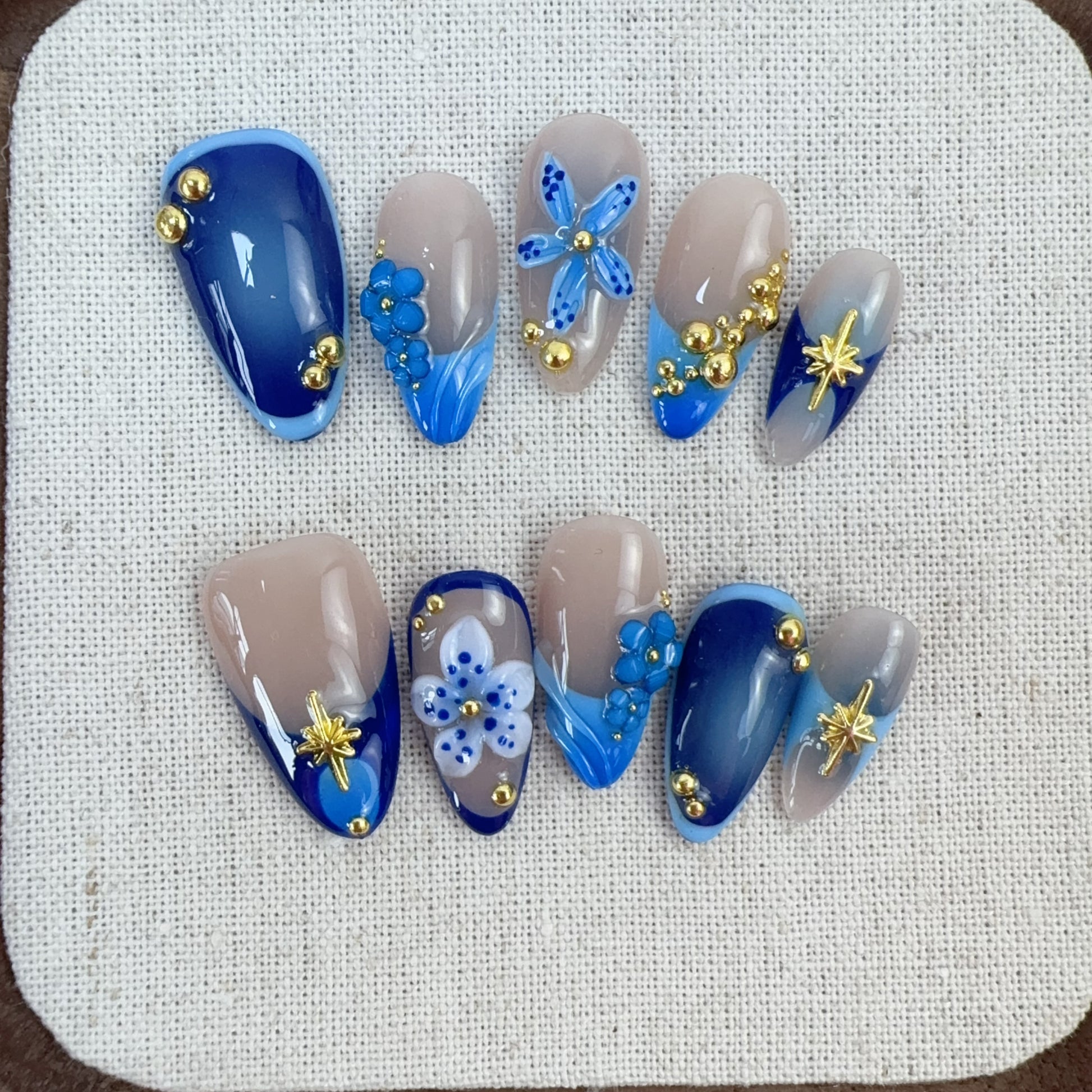 Full 10-piece set photo of Moonlit Petals blue French press-on nails on linen