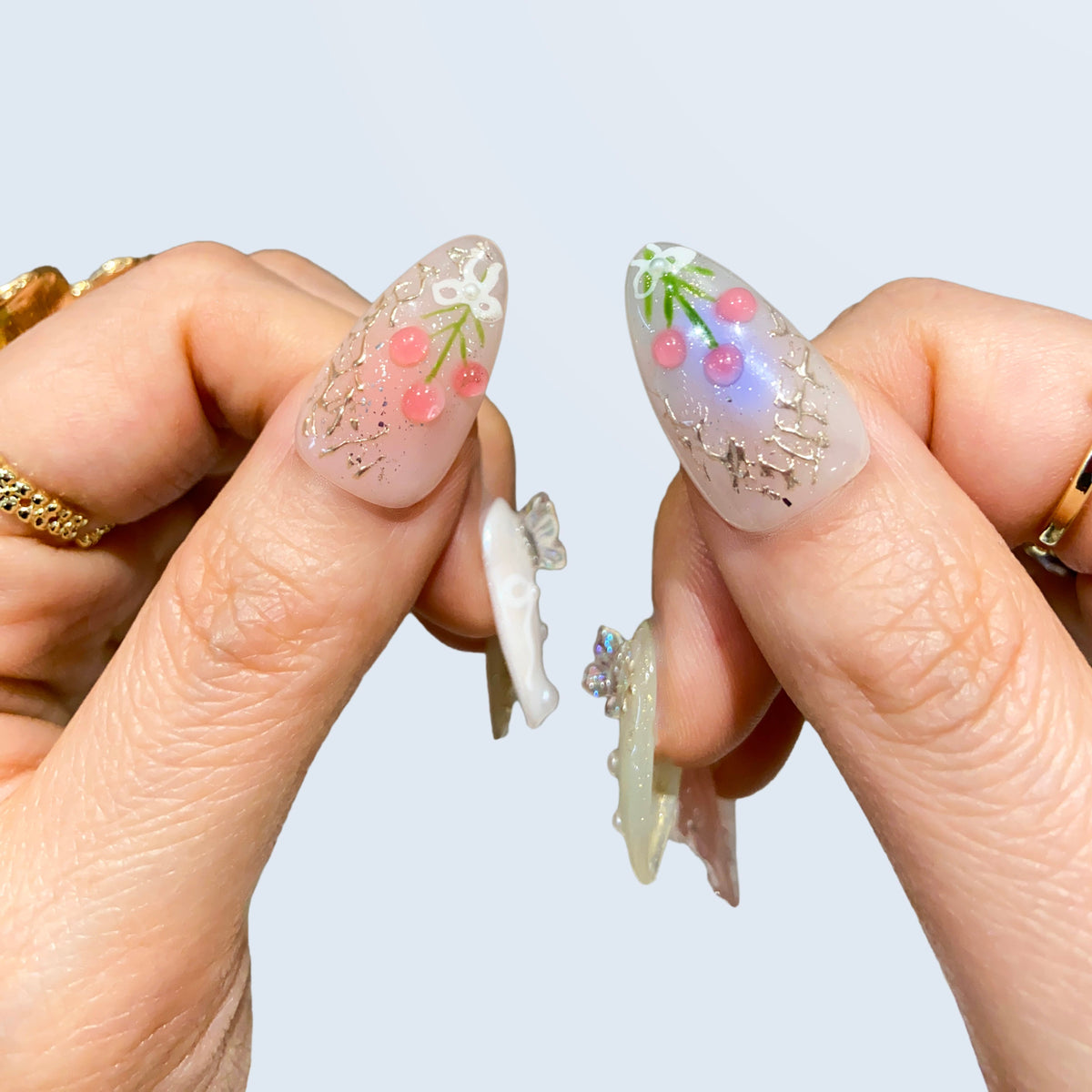 Thumbs closeup of Fairy Secrets nails showing 3D pink tulip bouquet and blue aura