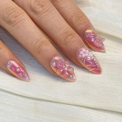 Close-up angle of Luminous Dream almond nails featuring 3D blossoms and crystals