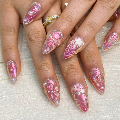On-hand try-on of Luminous Dream almond nails showing pink chrome shine and pearls