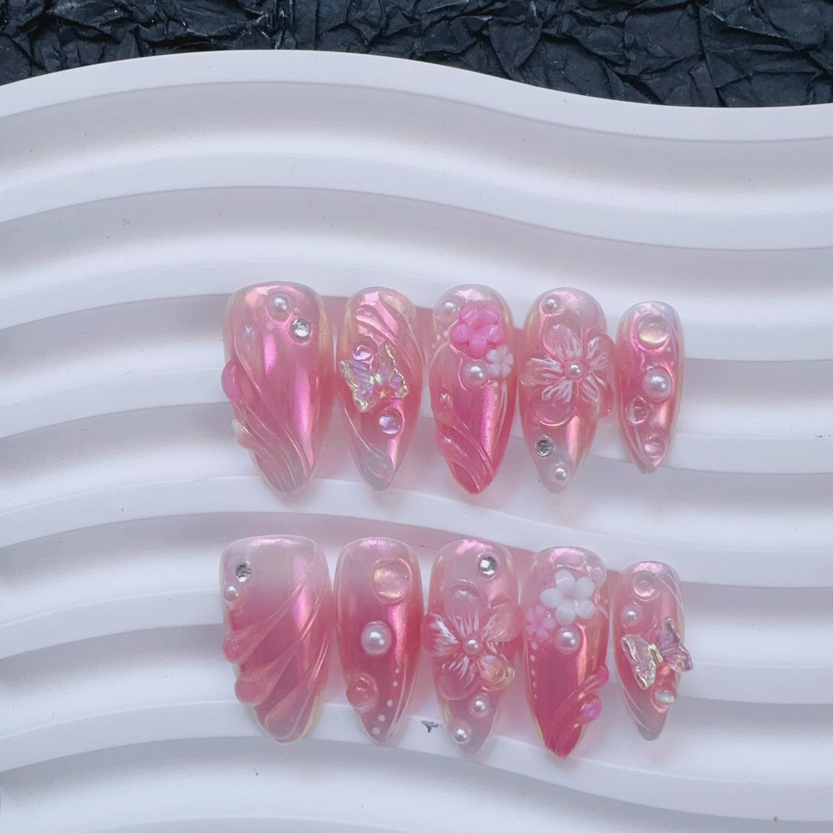 Flat lay display of Luminous Dream press-on nails on white ceramic wave tray
