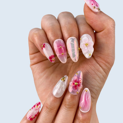 Side angle on-hand try-on of Petal Pop almond nails featuring blush aura and gold accents