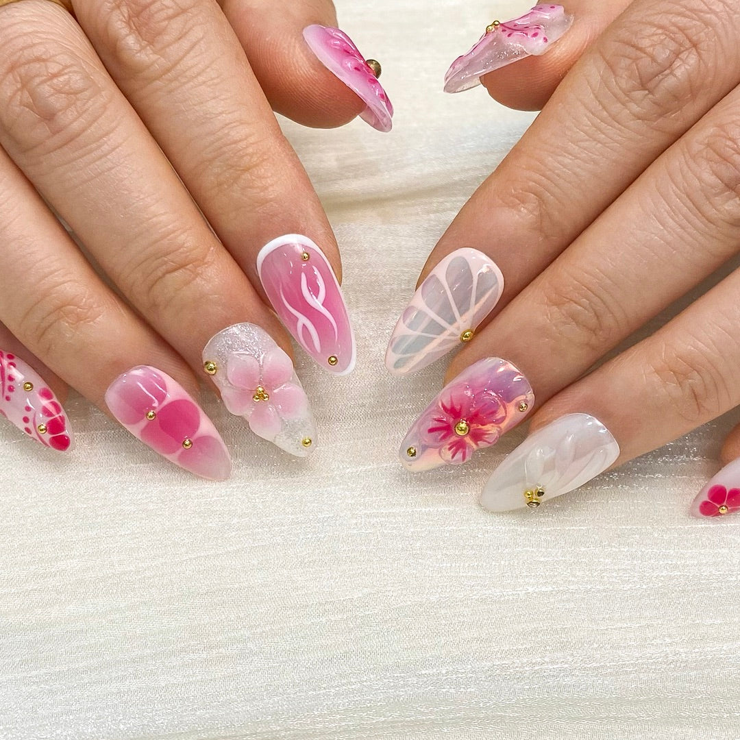 Top view of Petal Pop almond nails displaying blush gradient and delicate gold bead accents