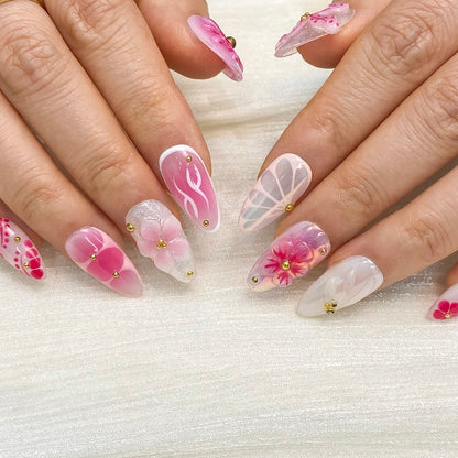 Top view of Petal Pop almond nails displaying blush gradient and delicate gold bead accents