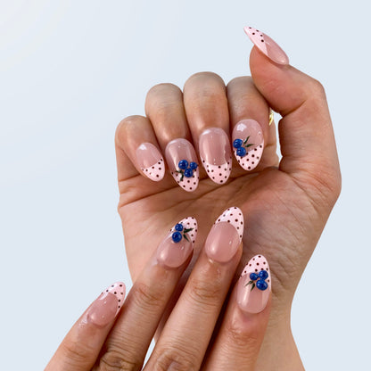 Handcrafted red gel fake nails in natural light for evening dates and holiday parties