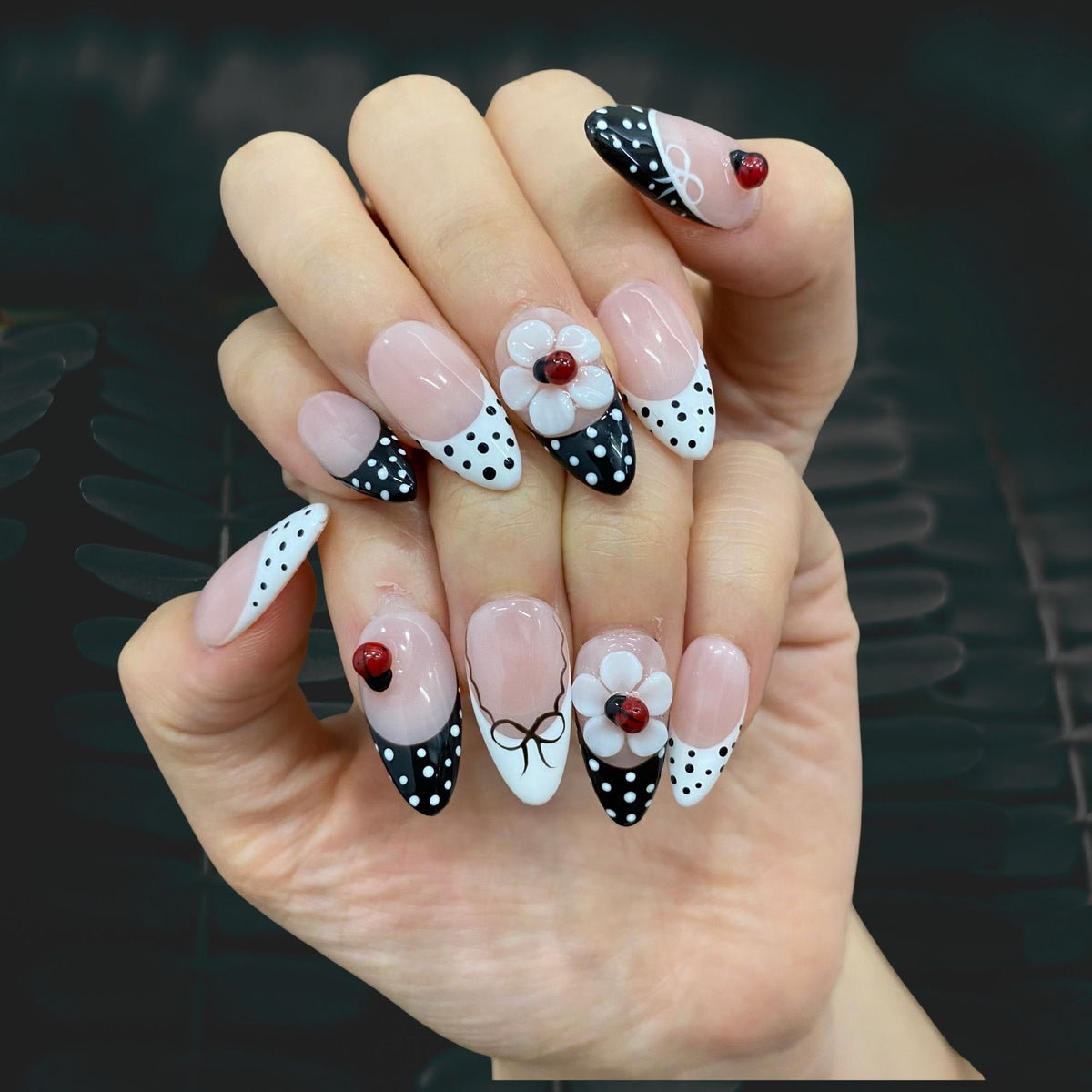 Retro Sweetheart medium almond nails worn on hand in indoor lighting with 3D flower art