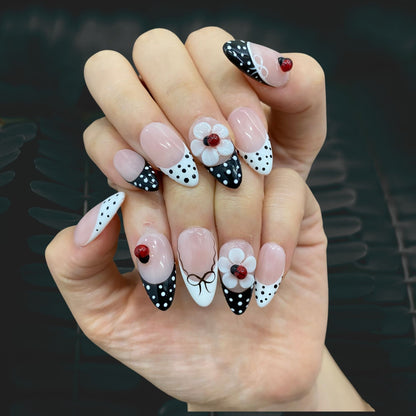 Retro Sweetheart medium almond nails worn on hand in indoor lighting with 3D flower art