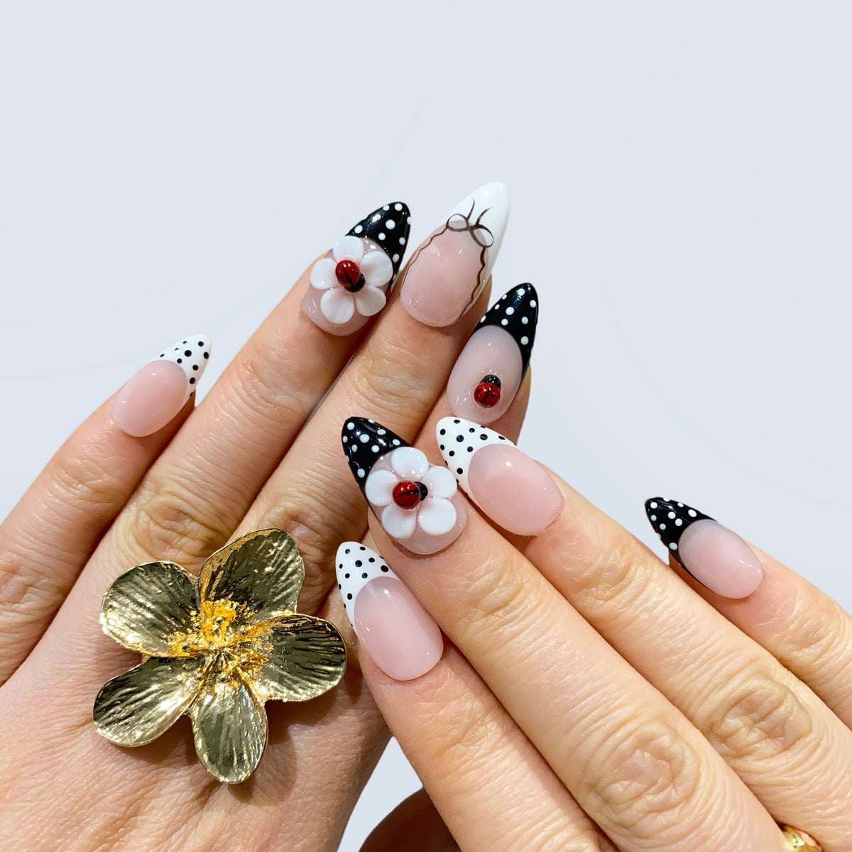 On-hand wear display of Retro Sweetheart nails with red ladybug and 3D floral crafts