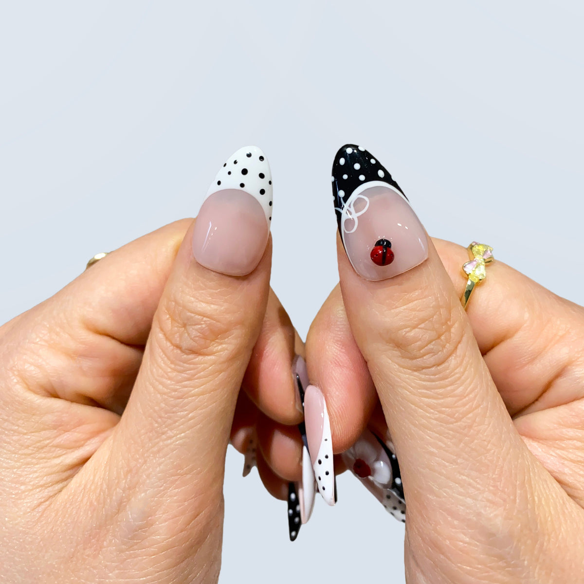 Detail view of Retro Sweetheart almond press-on nails with 3D ladybug accent on thumbs