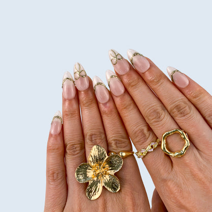 Angled view of Gilded Pearl Bow almond nails displaying clean girl French tips