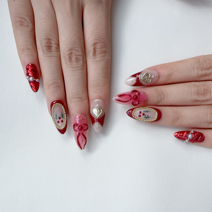 Full set wear display of Deck the Nails festive red and gold heart almond nails