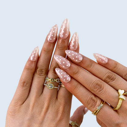 Both hands wearing Polka Muse minimalist white dotted press-on nails in light